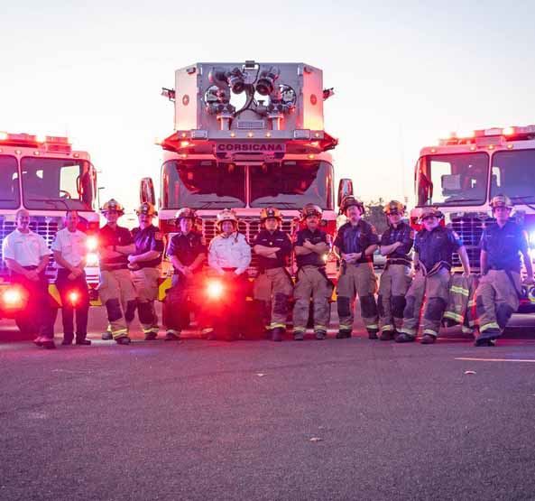 Corsicana Fire Fighters Standing in Front of Three Fire Trucks